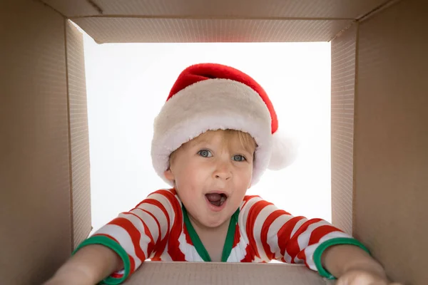 Überraschtes Kind packt Weihnachtsgeschenkschachtel aus — Stockfoto