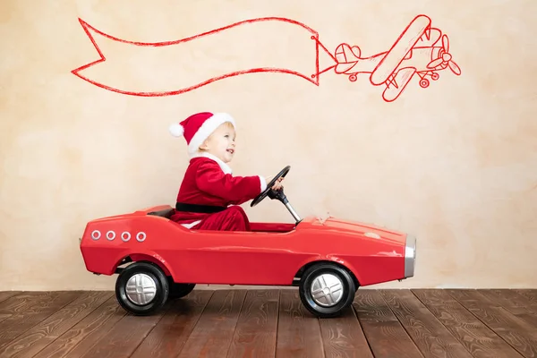 Criança feliz vestindo traje de Papai Noel jogando em casa — Fotografia de Stock