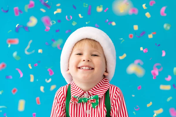 Happy Child klädd jultomten hatt mot blå bakgrund — Stockfoto