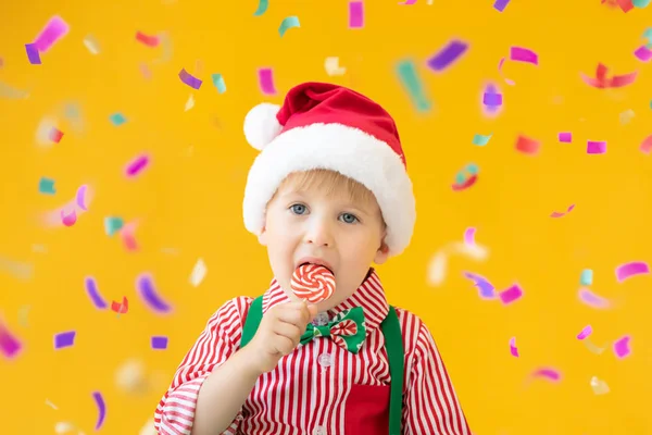 Glückliches Kind mit Lutscher in der Hand vor gelbem Hintergrund — Stockfoto