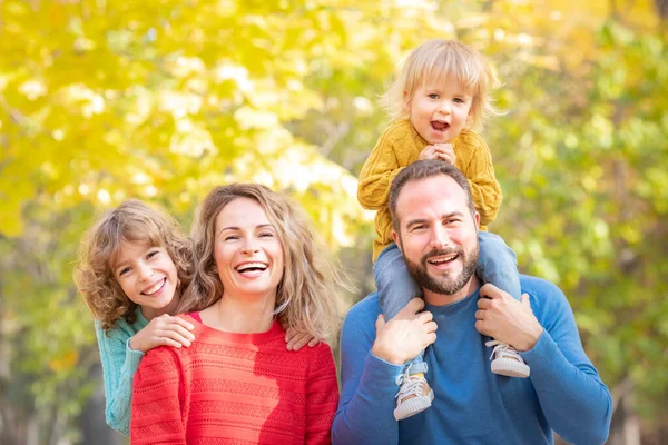 秋の公園で楽しい屋外を持つ幸せな家族 黄色い葉に対する子供と両親背景 — ストック写真