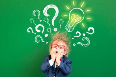 Sınıftaki üzgün çocuk öğrenci. Yeşil karatahtaya karşı korkmuş çocuk. Çevrimiçi eğitim ve e-öğrenme kavramı. Okula geri dön.