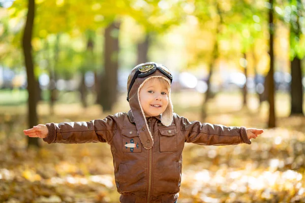 快乐的孩子在秋天的公园里玩得很开心 小孩飞行员在黄色模糊的树叶背景下玩耍 — 图库照片