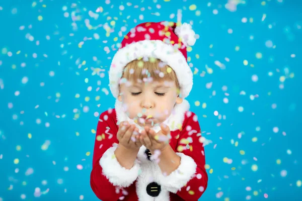 Criança Feliz Vestindo Traje Papai Noel Miúdo Soprar Confetes Contra — Fotografia de Stock