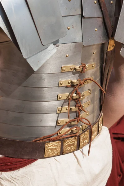 Details of a Roman legionary body armor as viewed from the back. Metal plates, copper or bronze fasteners, leather cords or lines to tie up the armor, leather belt.