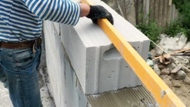 Tuğla ustası bir sıra tuğla daha yerleştiriyor.