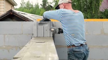 Tuğla ustası bir sıra tuğla daha yerleştiriyor.