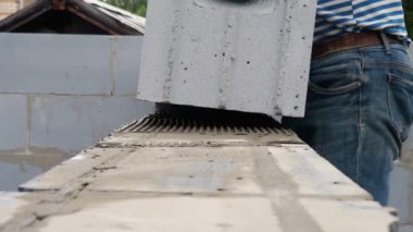 Tuğla ustası bir sıra tuğla daha yerleştiriyor.