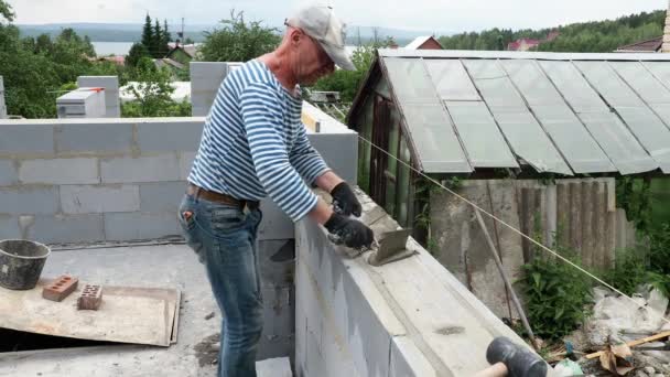 Bricklayer down next ground of bricks in site — стоковое видео