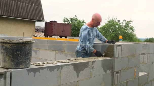Bricklayer down next ground of bricks in site — стоковое видео