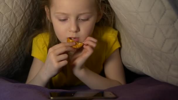 Kis lány telefonnal és cookie-val — Stock videók