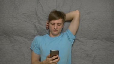 Genç adam Ile telefon üzerinde yatak