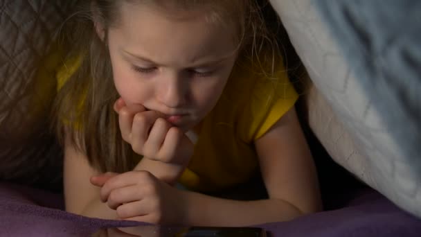 Маленька дівчинка з телефоном вночі — стокове відео
