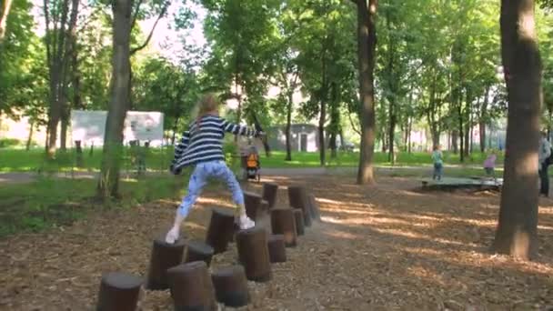 Ein kleines Mädchen auf Stümpfen — Stockvideo