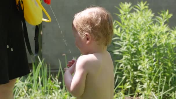 Häller vatten på lilla pojken — Stockvideo