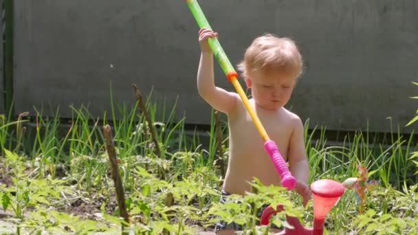 小さな男の子の水のおもちゃの裏庭 — ストック動画