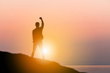 Adam ayakta bir taş tropikal günbatımı keyfini siluet / gündoğumu akşam gökyüzünde Beach arka plan, mutluluk ve aktif bir yaşam konsepti.