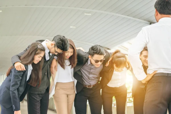 Group of Successful business team is hugging standing outside office people and teamwork concept