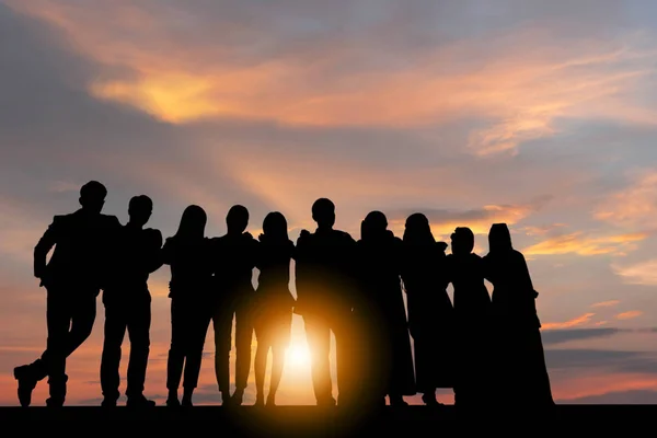 Sunset akşam gökyüzü arka plan iş insanlar kutlama başarı mutluluk takım ayakta kolları olan silüeti geçti