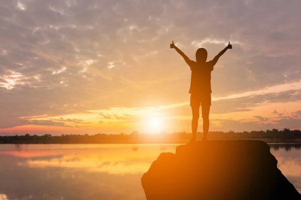 Silhouette of Woman Celebration Success Happiness on a Stone Eve