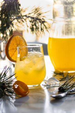 seçici odak, portakal ferahlatıcı ev yapımı limonata buz ve meyve dilimleriyle, karanlık bir masanın üzerinde konturlu bir ışıkta.