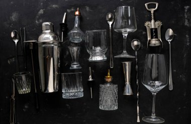 Cam tabaklar, bardaklar ve çelik kaşıklarla barmenlik ekipmanları.