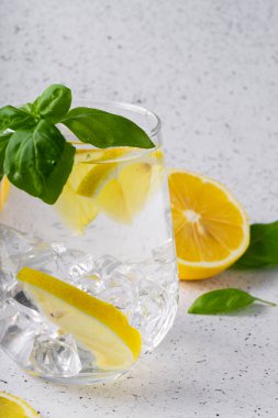 seçici odak, limon ve fesleğenle açık arkaplanda saf ferahlatıcı su.