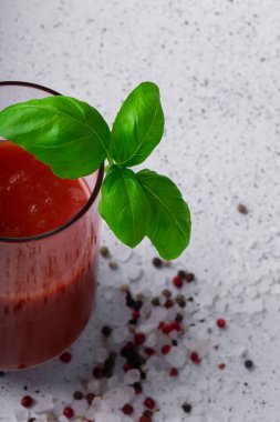 seçici odak, domates suyu, baharatlı domates suyu ve bir tutam yeşil fesleğen.