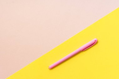 seçici odak, model, kağıt rengi arka plan pembesi ve sarı üzerine pembe kalem. Kopyalama alanı