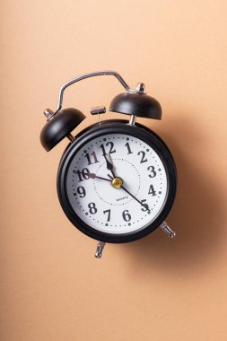 Seçici odaklanma. Elleri ve numaraları olan tıklayan siyah bir saat. yumuşak kahve monokrom arka planında