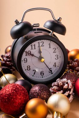 Seçici odaklanma. Elleri on ikiye on kala yılbaşı saati. Noel plastik topları ve Noel oyuncakları ile
