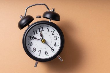 Seçici odaklanma. Elleri ve numaraları olan tıklayan siyah bir saat. yumuşak kahve monokrom arka planında