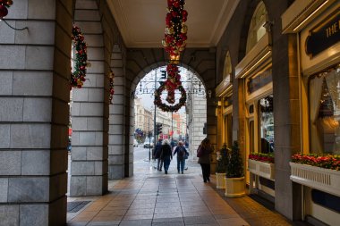 Londra, İngiltere - 27 Kasım 2017: İnsanlar goimg Ritz hotel, Noel çelenk ile dekore edilmiş kemerlerin aracılığıyla