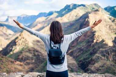 Eller yukarı kadınla mutlu traveler Mirador del Molino gelen Gran Canaria adada doğal dağ manzara keyfini çıkarın. Seyahat kavramı