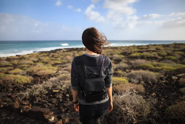 ランサローテ島の海岸を楽しんでいるバックパックを持つ少女 旅行の概念 — ストック写真