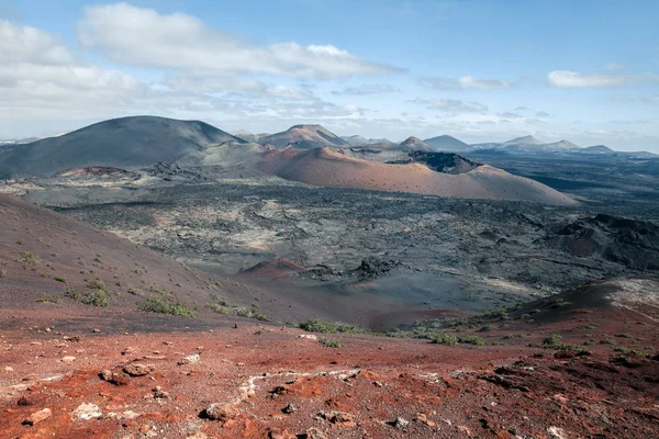 Unique volcanic landscapes of Timanfaya National Park, Lanzarote, Canary island. Nature background. Red and black volcanic mountains.