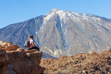 Gezgin adam rock yanardağ El Teide, Kanarya Adaları, İspanya'nın kenarında oturan sırt çantası ile
