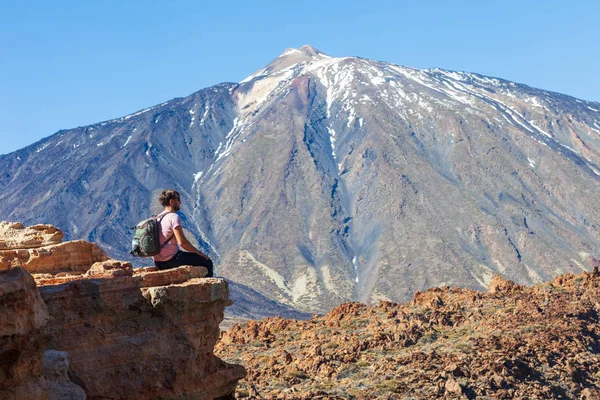 Gezgin adam rock yanardağ El Teide, Kanarya Adaları, İspanya'nın kenarında oturan sırt çantası ile