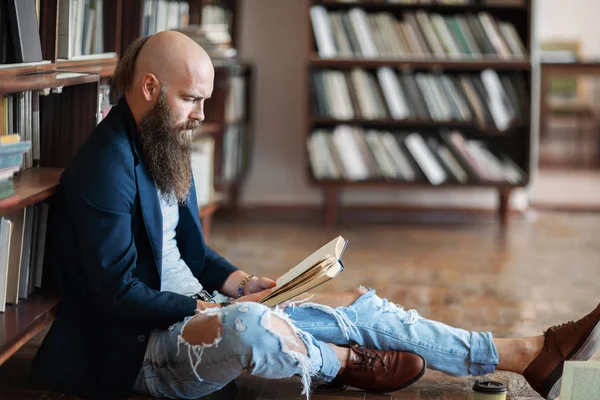 Hipster Stylowy Człowiek Czytając Książkę Siedząc Podłodze Bibliotece Lub Księgarni — Zdjęcie stockowe