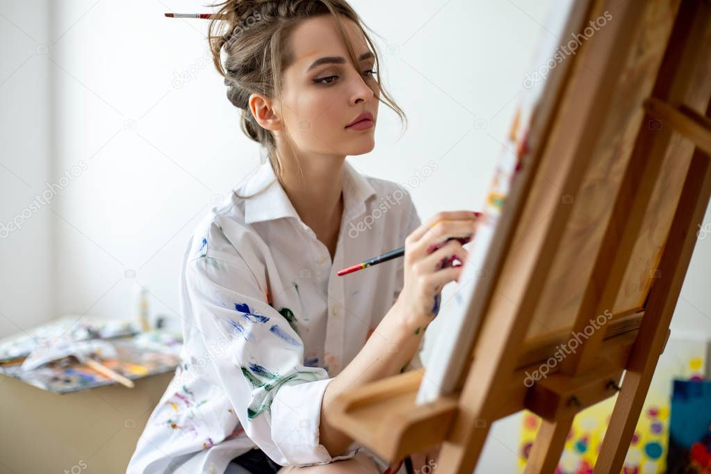 Closeup of woman painting on canvas in studio. Creative concept