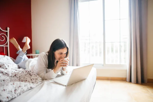 Doordachte Vrouw Ontspannen Bed Drinken Koffie Met Laptop Thuis Rest — Stockfoto