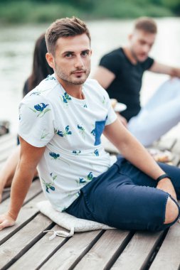 Yakışıklı delikanlı arkadaş grubu ahşap iskele üzerinde rahatlatıcı. Tatil kavramı