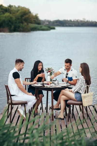 一群年轻的朋友在户外河畔餐厅吃饭 玩得很开心 乐趣和餐饮概念 — 图库照片