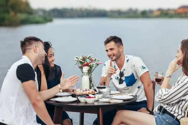 Grupa Młodych Przyjaciół Jedzenia Zabawy Restauracji Świeżym Powietrzu Nad Rzeką — Zdjęcie stockowe