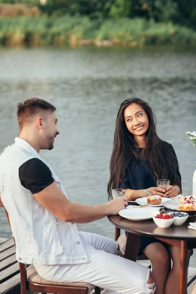 Happy loving couple enjoying breakfast in nature. Love, dating, food concept