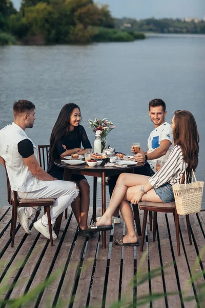 Jóvenes Amigos Comiendo Divirtiéndose Restaurante Junto Río —  Fotos de Stock