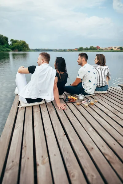 Bakifrån Gruppen Unga Vänner Avkopplande Floden Piren Sitter Raden — Stockfoto