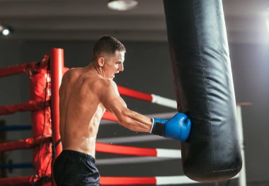 Erkek boxer kum torbası boks stüdyoda isabet. Spor eğitim kavramı