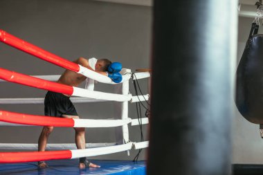 Yorgun boksör boks ringi, eldiven kafasına dinlenme. Savaşta kırmak