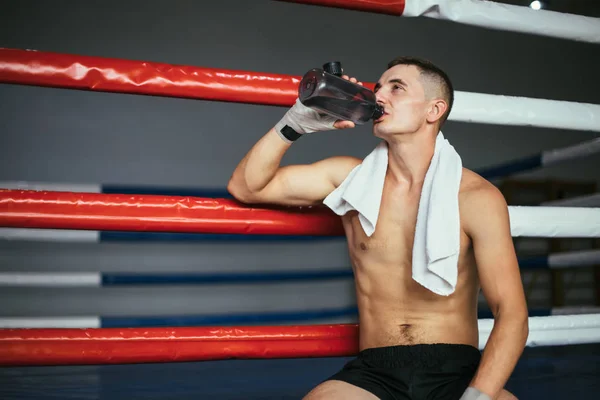 男拳击手在拳击比赛或锻炼运动后喝水 — 图库照片